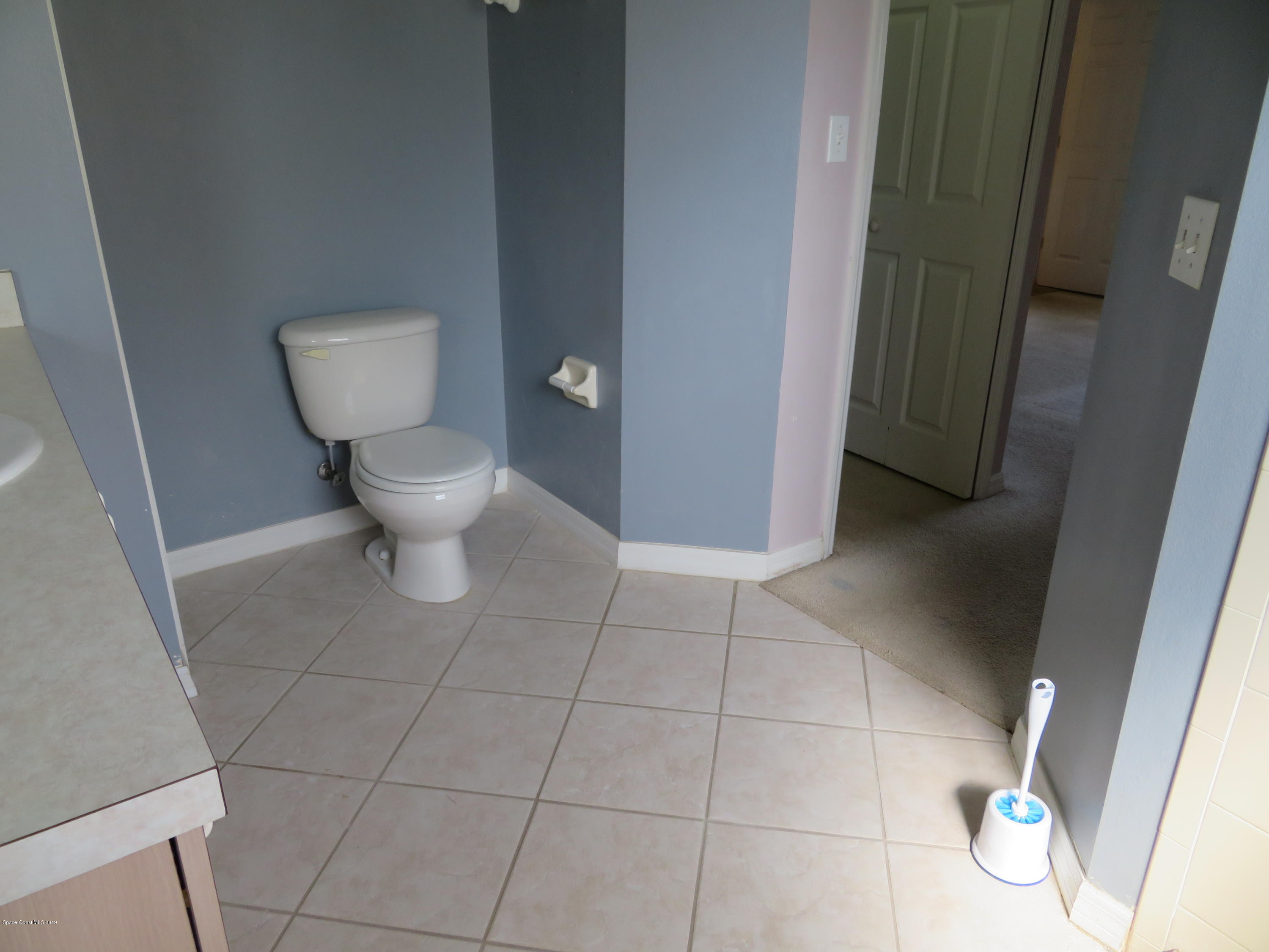 801 Clifton Road Southeast Palm Bay, FL 32909 - Photo 13 of 25 a white toilet sitting next to a small bathroom