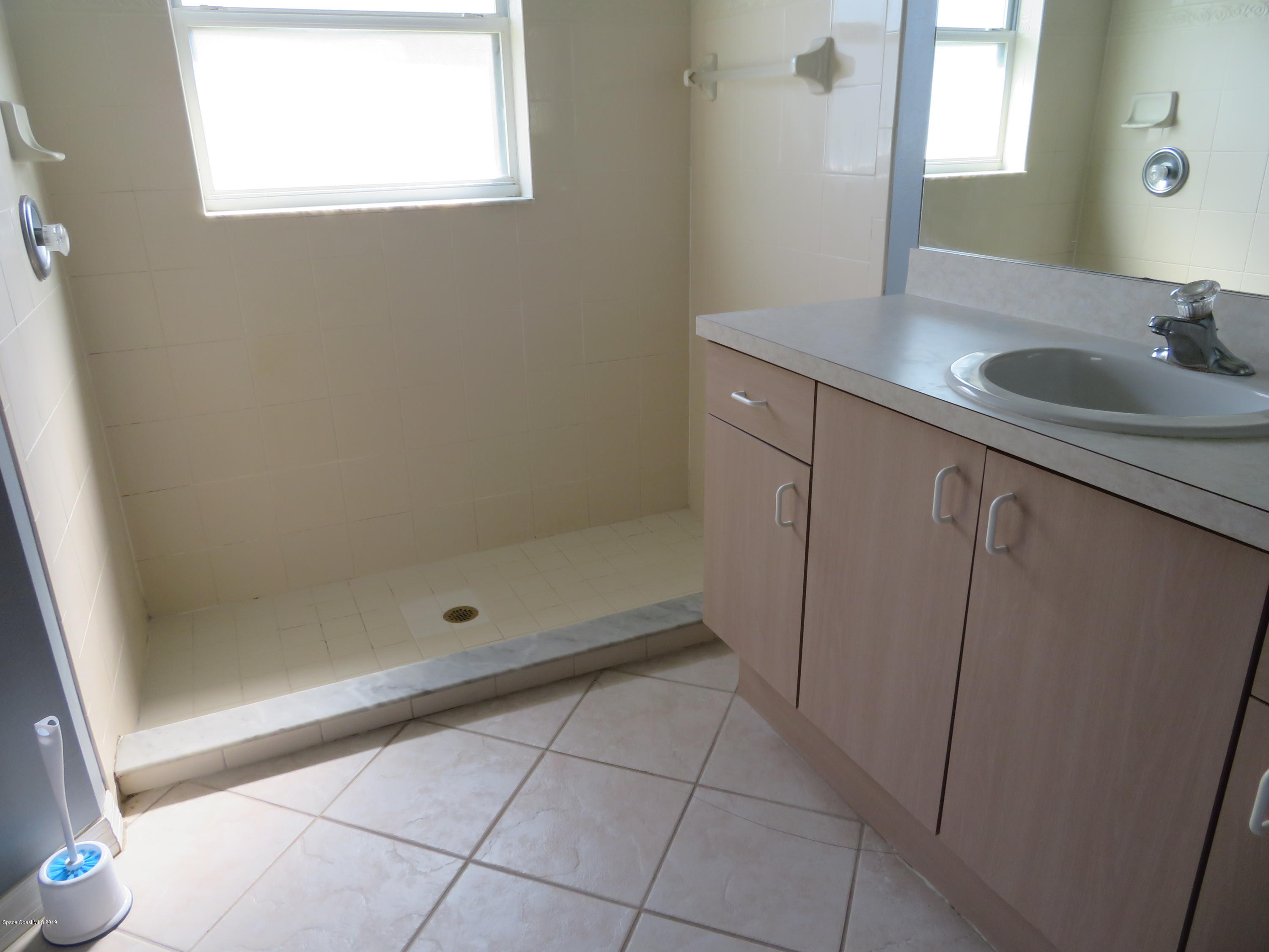 801 Clifton Road Southeast Palm Bay, FL 32909 - Photo 14 of 25 a bathroom with a granite countertop sink a mirror and shower
