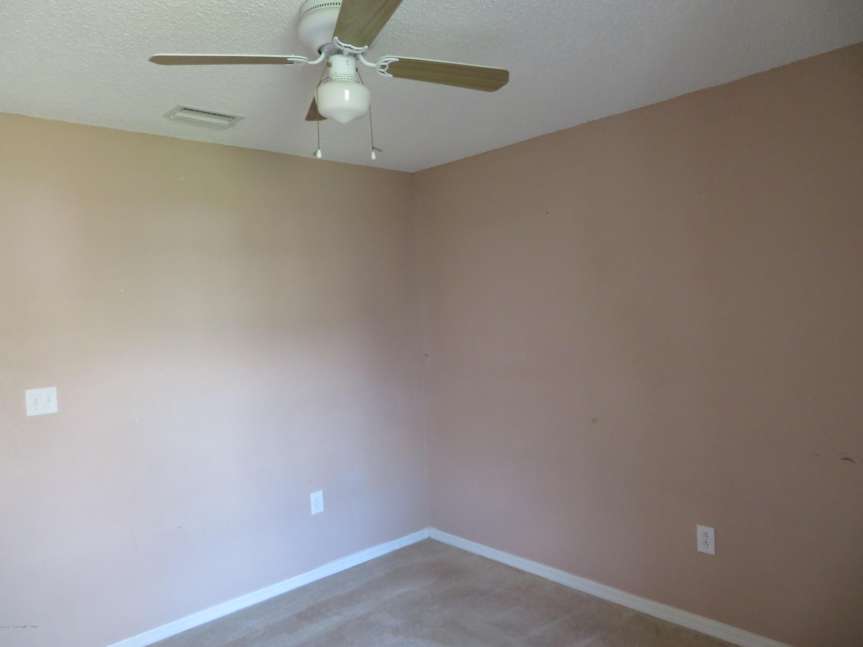 801 Clifton Road Southeast Palm Bay, FL 32909 - Photo 18 of 25 an empty room with a ceiling fan and carpet