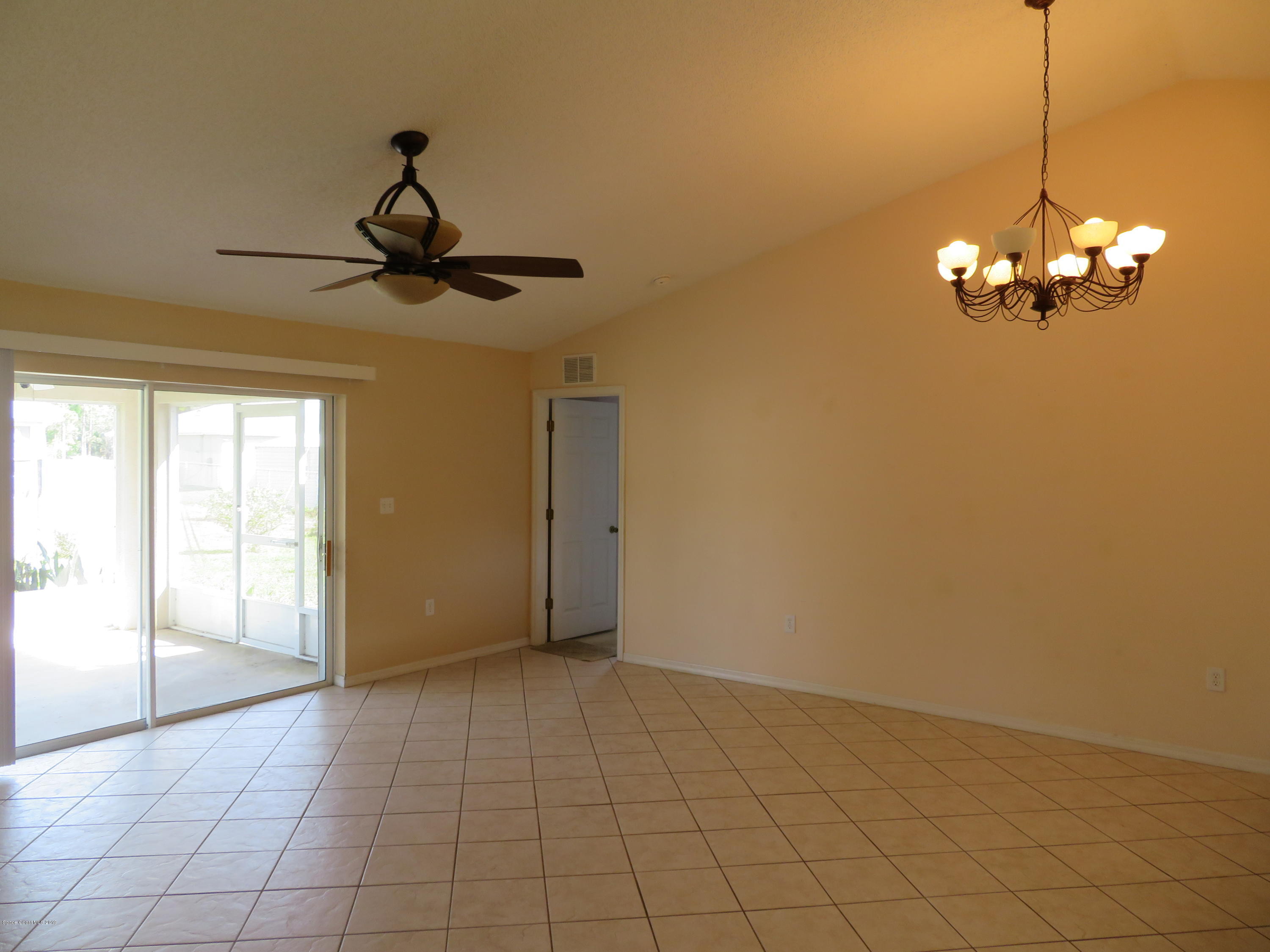 801 Clifton Road Southeast Palm Bay, FL 32909 - Photo 5 of 25 a view of a livingroom with a chandelier fan and windows