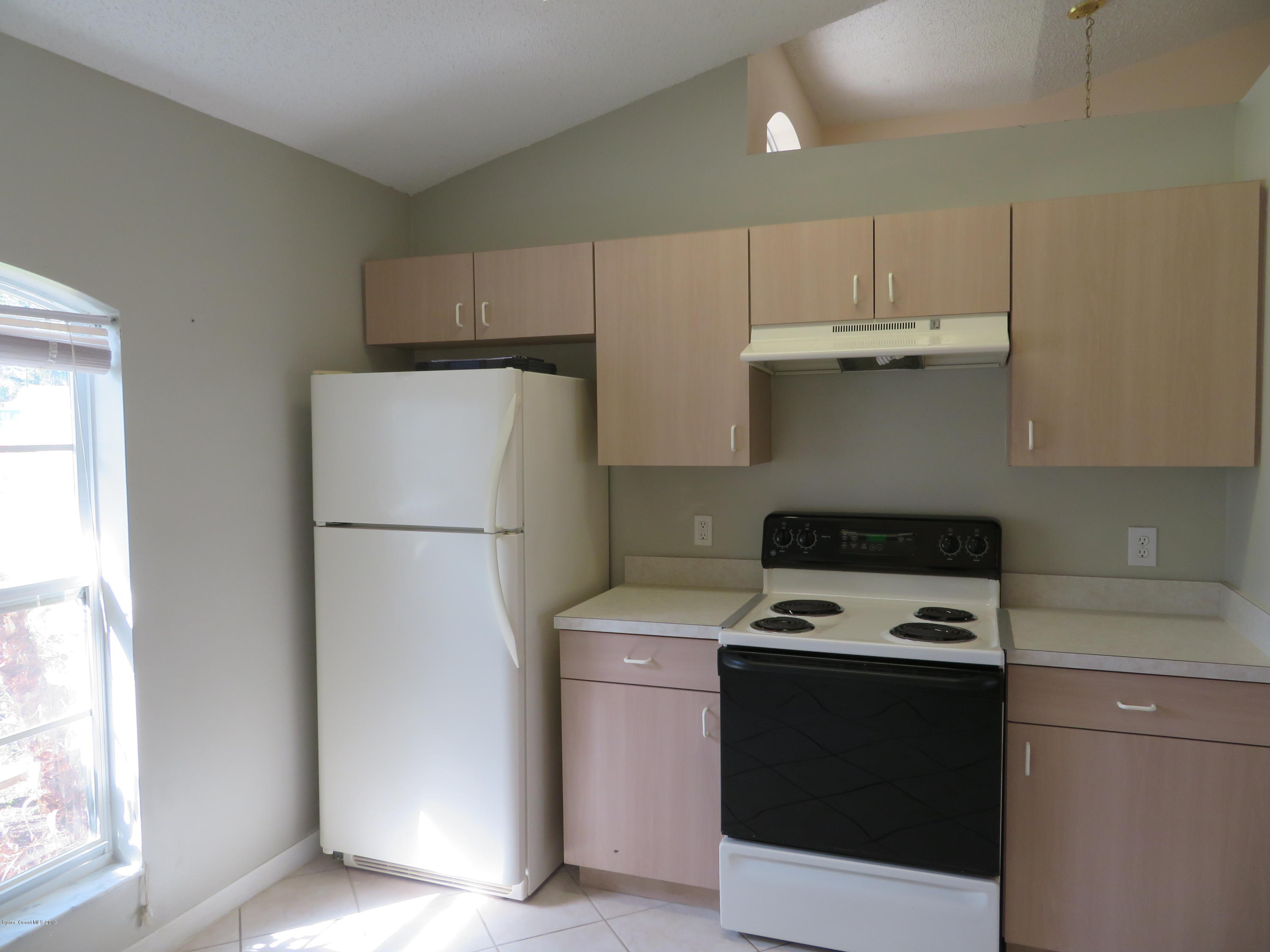 801 Clifton Road Southeast Palm Bay, FL 32909 - Photo 8 of 25 a kitchen with a refrigerator sink stove and cabinets