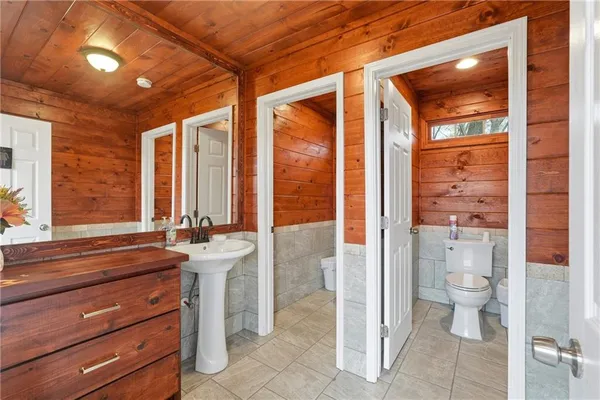 a bathroom with a sink a toilet and shower