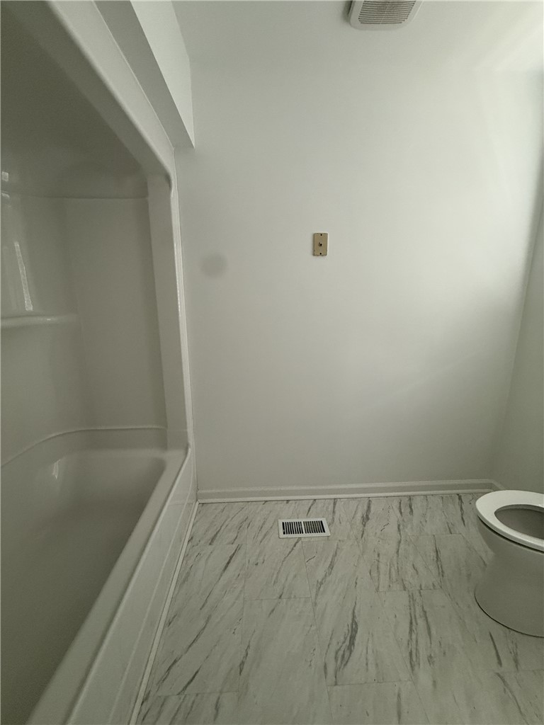 311 Dixie Drive Seneca, SC 29672 - Photo 4 of 8 This bathroom features a sleek bathtub and modern flooring, creating a clean and functional space.