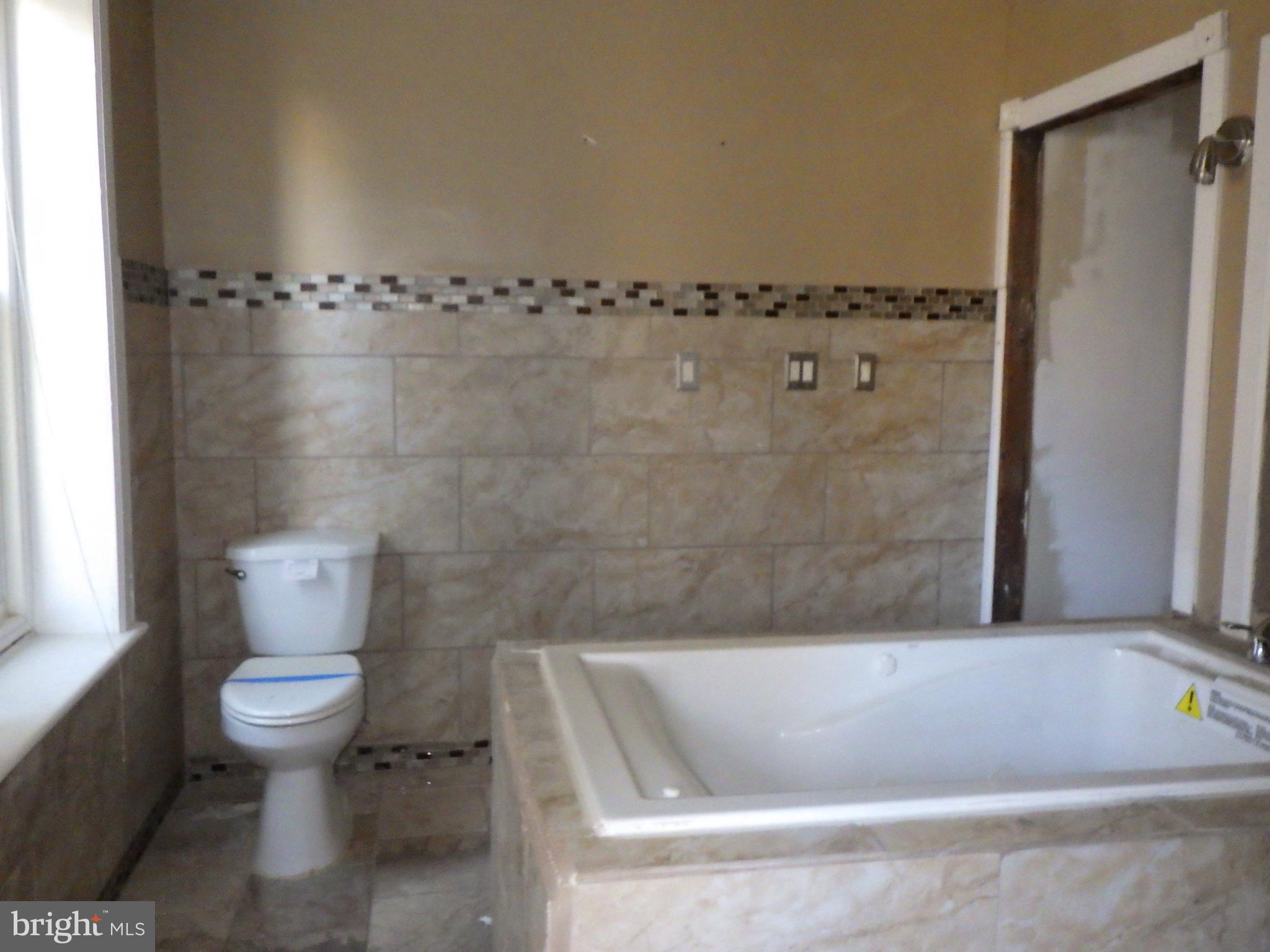260 Harvey Street Philadelphia, PA 19144 - Photo 11 of 25 a bathroom with a bathtub and a toilet