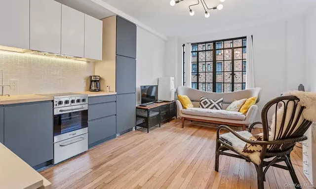 a kitchen with stainless steel appliances granite countertop a stove top oven a sink dishwasher and wooden cabinets with wooden floor