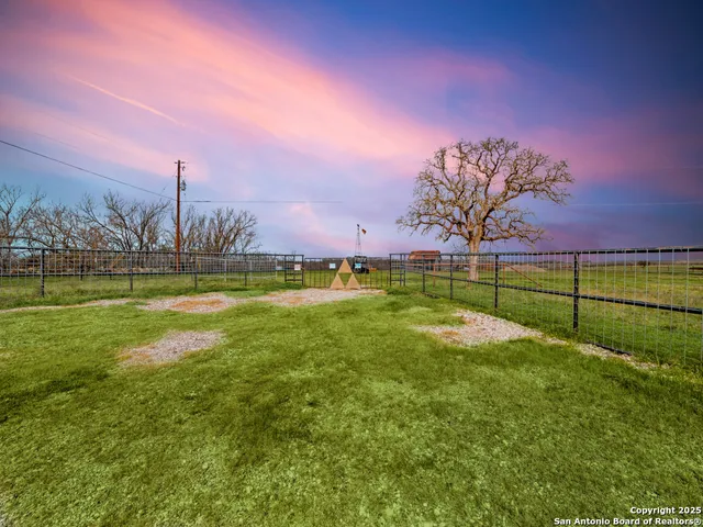a view of a big yard with a table & chairs
