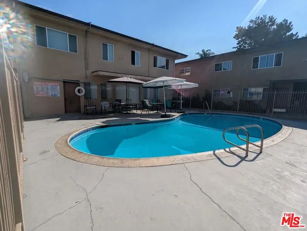 a view of a house with backyard swimming pool and sitting area