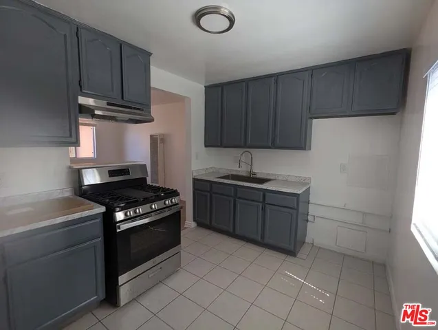 a kitchen with granite countertop a stove and a sink