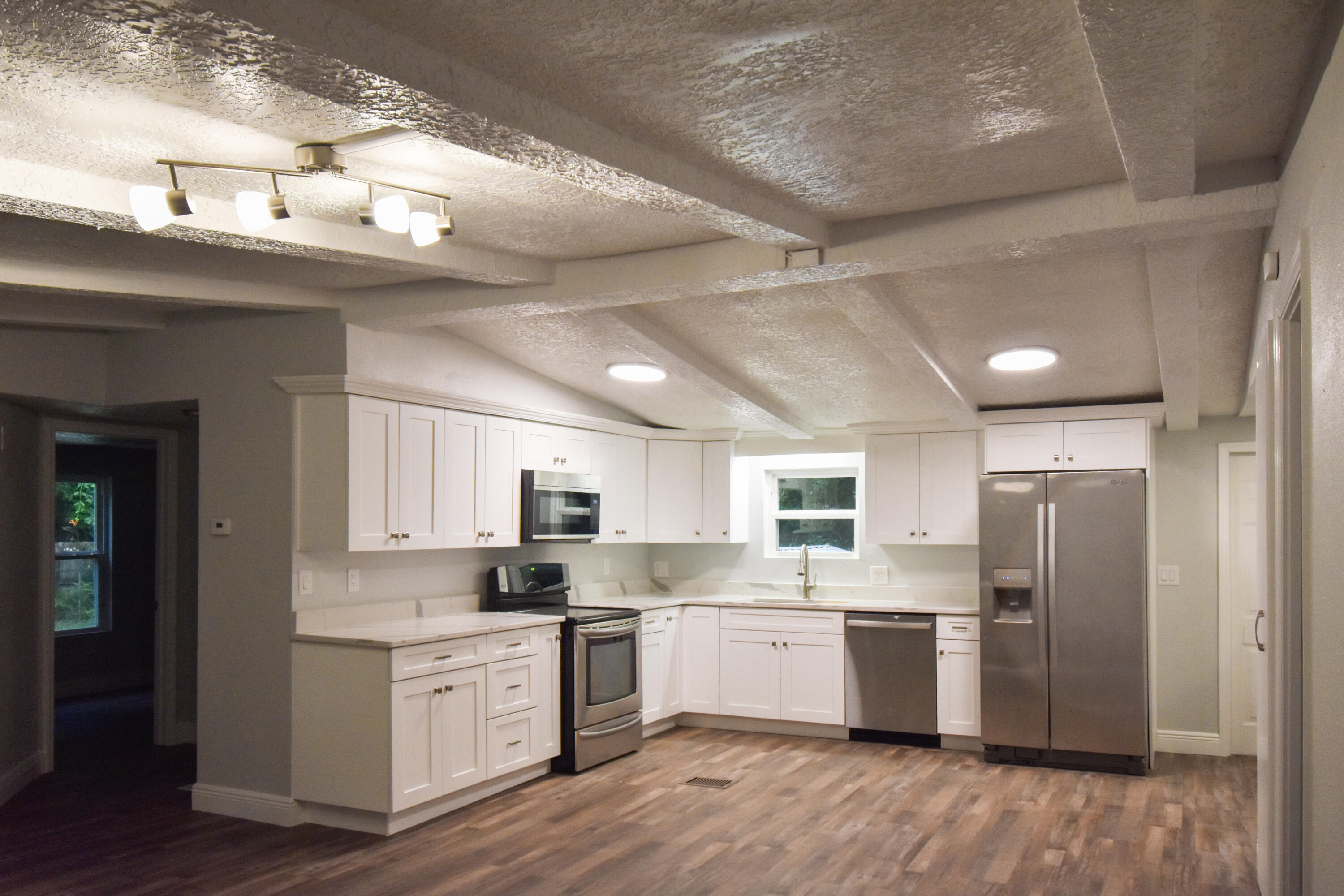 24050 Bass Road Astor, FL 32102 - Photo 7 of 22 a kitchen with a refrigerator a sink dishwasher with a stove and wooden floor