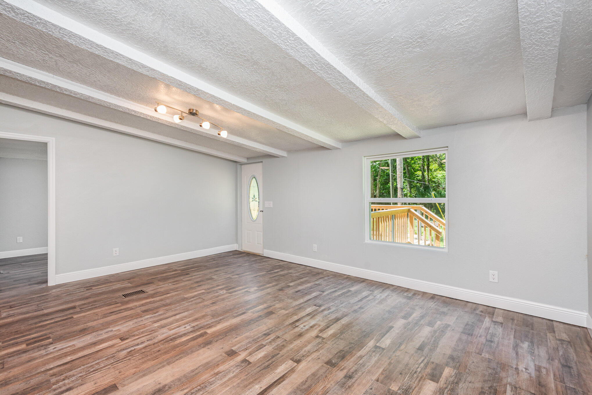 24050 Bass Road Astor, FL 32102 - Photo 9 of 22 an empty room with wooden floor and windows