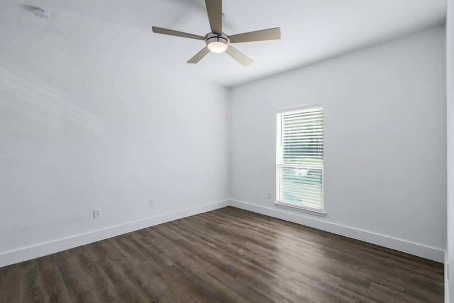 114 East 31st Street, Unit 314 Austin, TX 78705 - Photo 12 of 20 an empty room with wooden floor chandelier fan and windows
