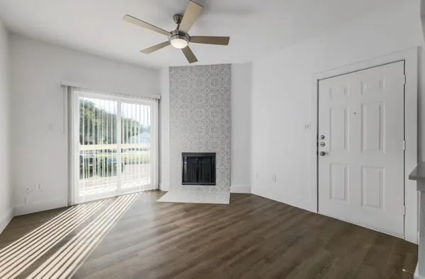 a view of a livingroom with wooden floor and a ceiling fan