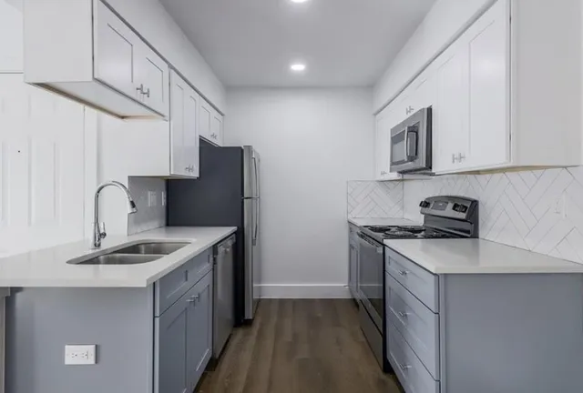 a kitchen with stainless steel appliances granite countertop a sink stove and refrigerator