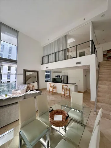 a living room with furniture a flat screen tv and kitchen view