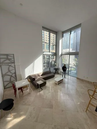 a living room with furniture and floor to ceiling window