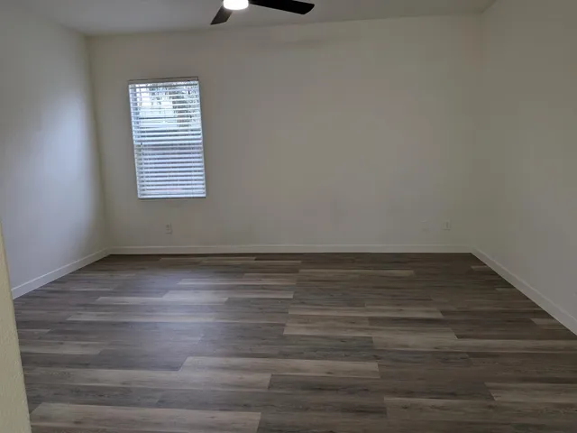 a view of empty room with window and ceiling fan