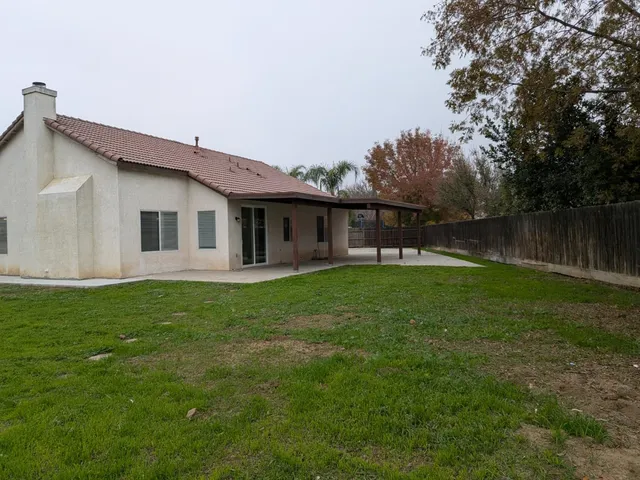 a view of a house with backyard and trees