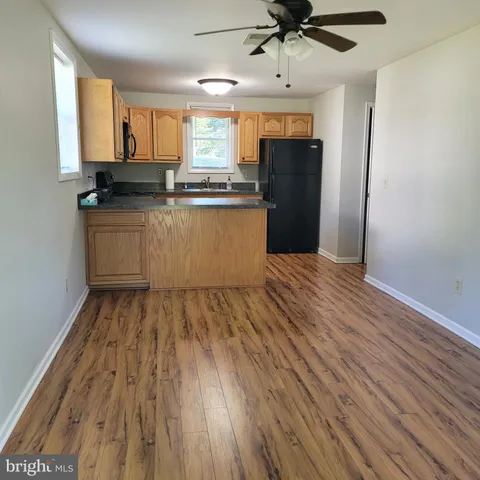 a kitchen with wooden floors and white cabinets