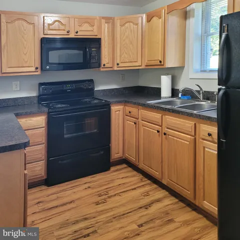 a kitchen with granite countertop wooden cabinets and a stove top oven