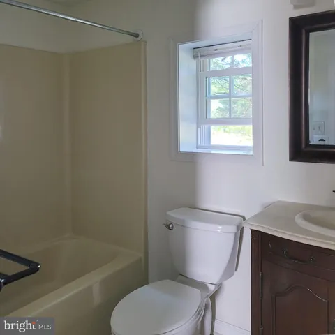 a white toilet sitting next to a bath tub