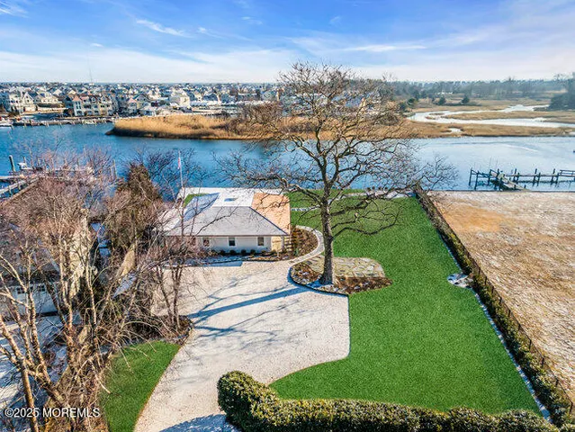 an aerial view of residential houses with outdoor space and ocean view