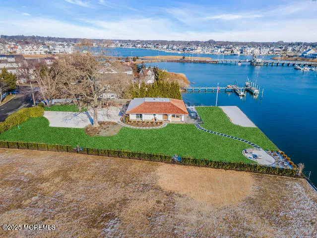 an aerial view of a house with a garden and lake view