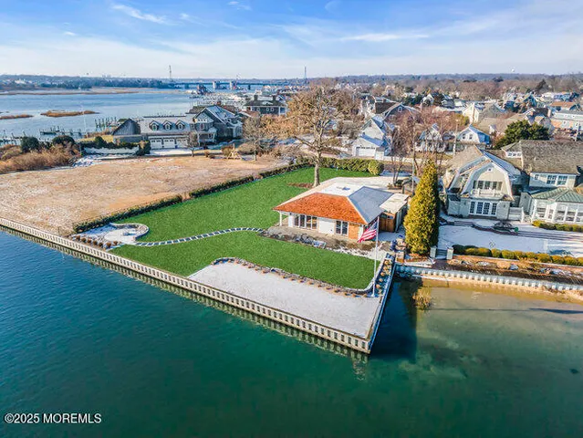 an aerial view of a house with a garden and lake view