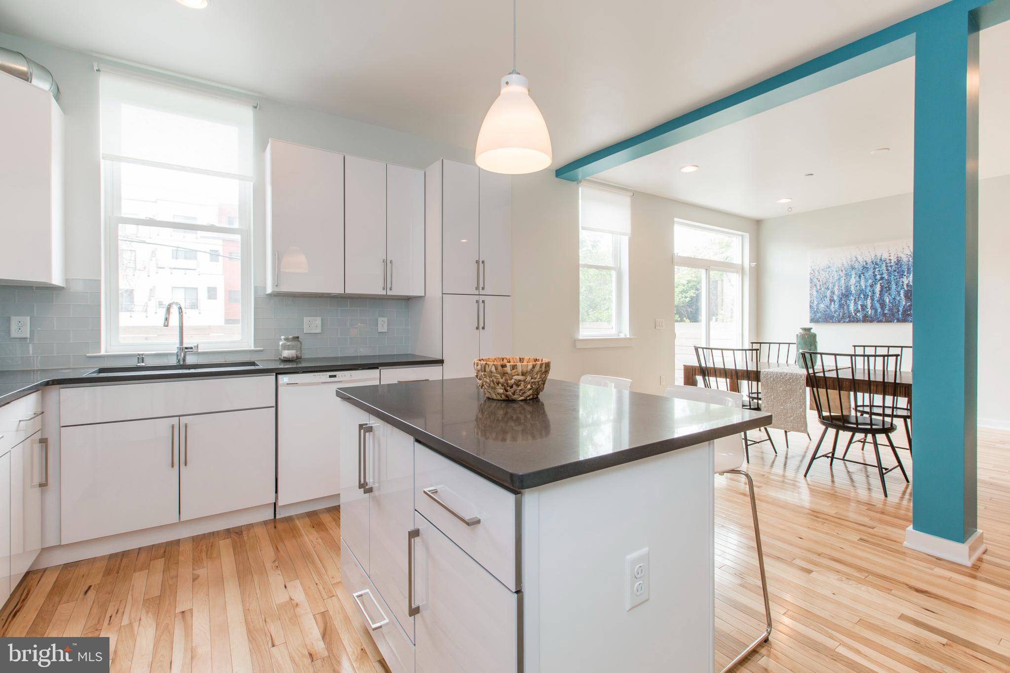 3039-41 Baltz Street Philadelphia, PA 19121 - Photo 16 of 35 a kitchen with granite countertop a stove a sink and white cabinets with wooden floor