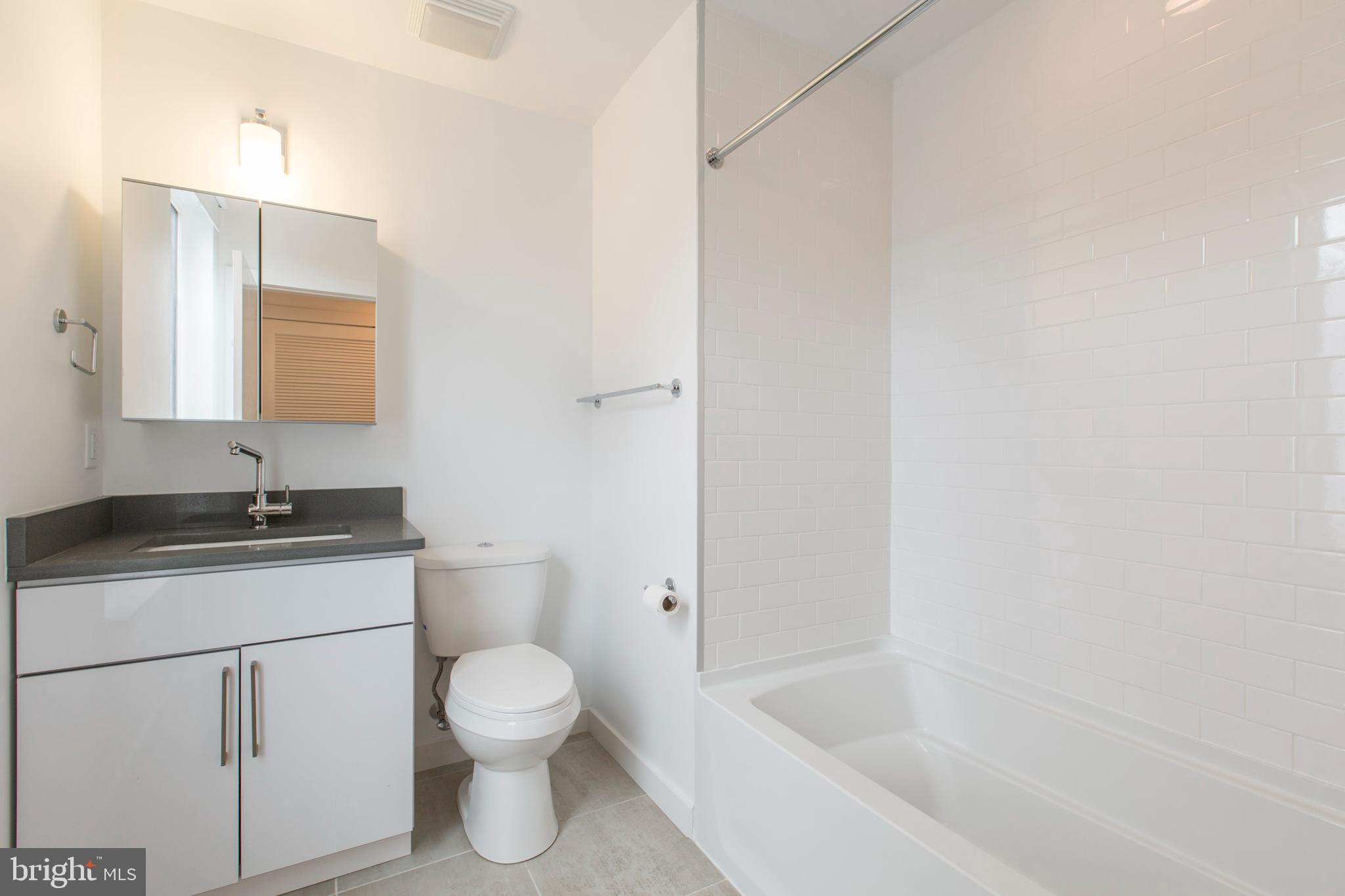 3039-41 Baltz Street Philadelphia, PA 19121 - Photo 19 of 35 a bathroom with a granite countertop toilet a sink and a bathtub