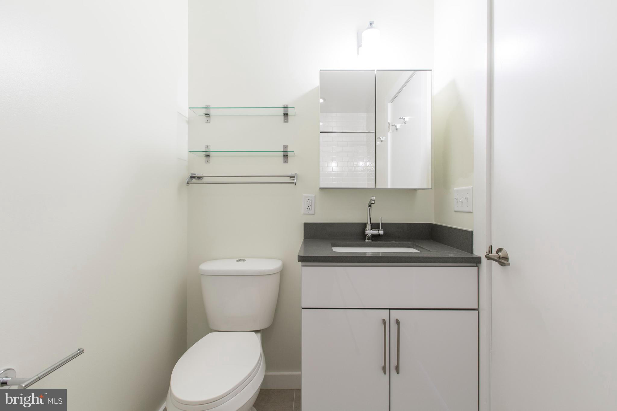 3039-41 Baltz Street Philadelphia, PA 19121 - Photo 22 of 35 a bathroom with a granite countertop toilet sink and mirror