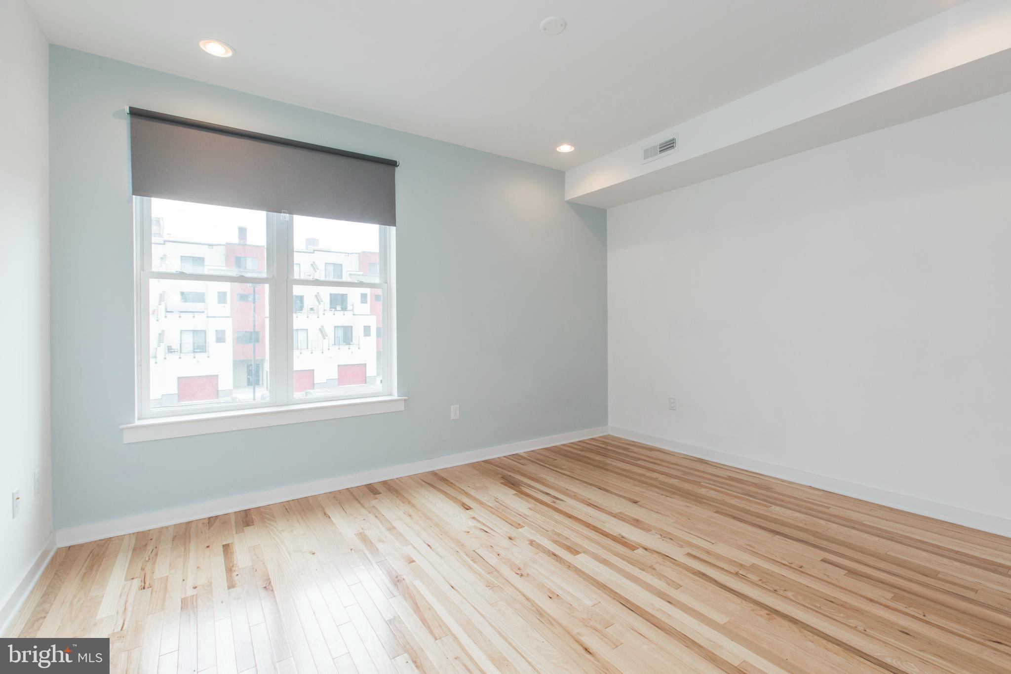 3039-41 Baltz Street Philadelphia, PA 19121 - Photo 24 of 35 an empty room with wooden floor and windows