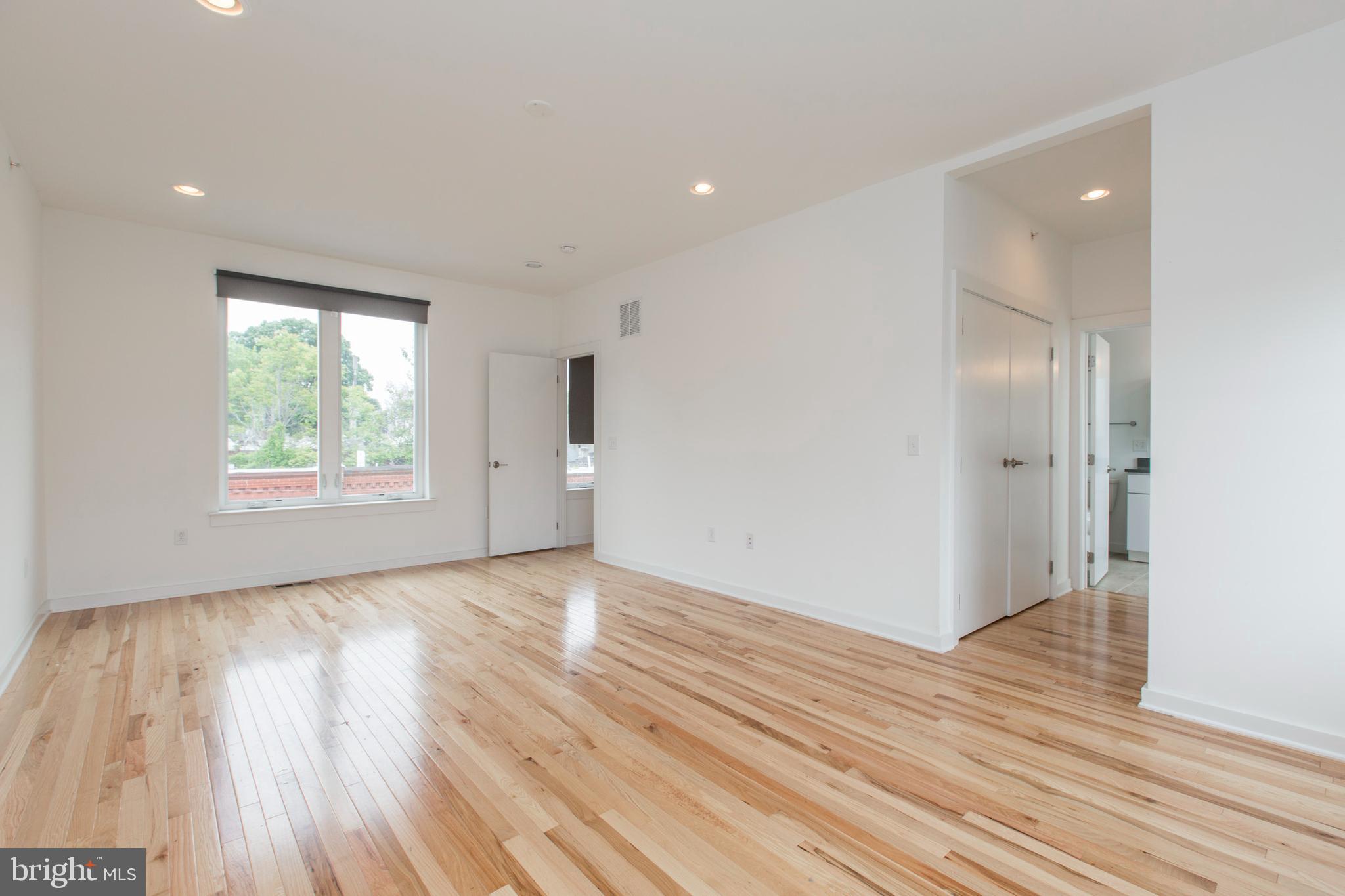 3039-41 Baltz Street Philadelphia, PA 19121 - Photo 28 of 35 an empty room with wooden floor and windows