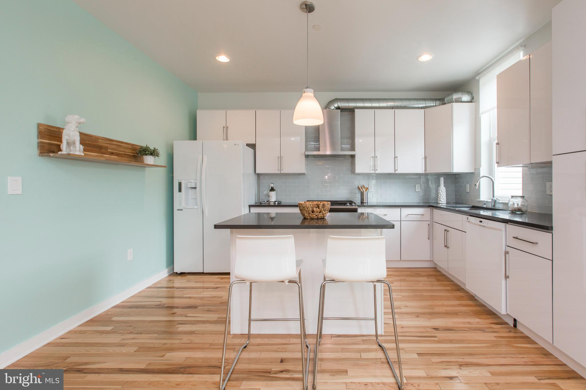 3039-41 Baltz Street Philadelphia, PA 19121 - Photo 5 of 35 a kitchen with stainless steel appliances granite countertop a refrigerator sink and white cabinets