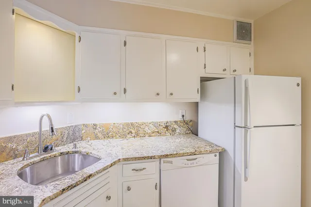 a kitchen with granite countertop a sink stove and cabinets