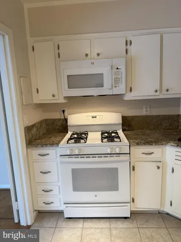 a kitchen with granite countertop a sink and a refrigerator