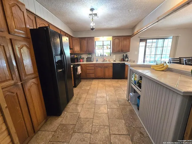 a large kitchen with a stove a refrigerator a sink and dishwasher