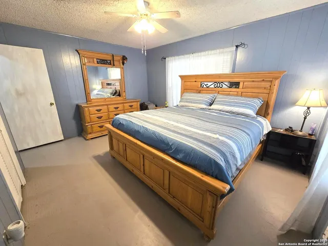 a bedroom with a bed and a large mirror on dresser