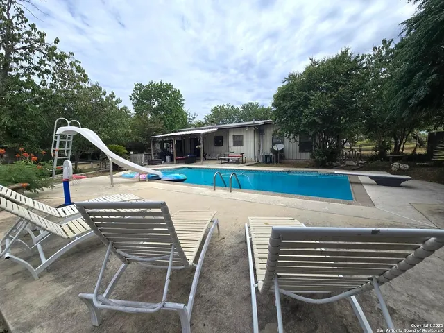a view of a patio with table and chairs with wooden floor and fence
