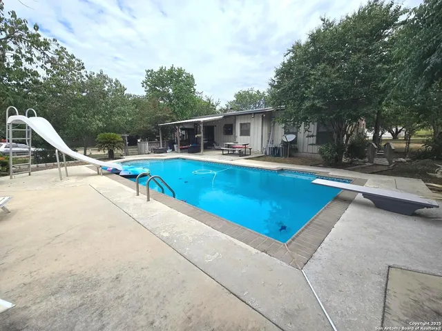 a view of a house with swimming pool and sitting area