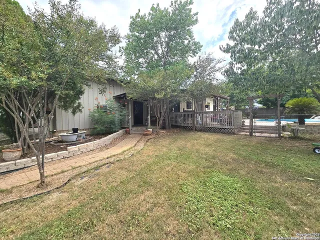 a view of a house with a yard and tree s