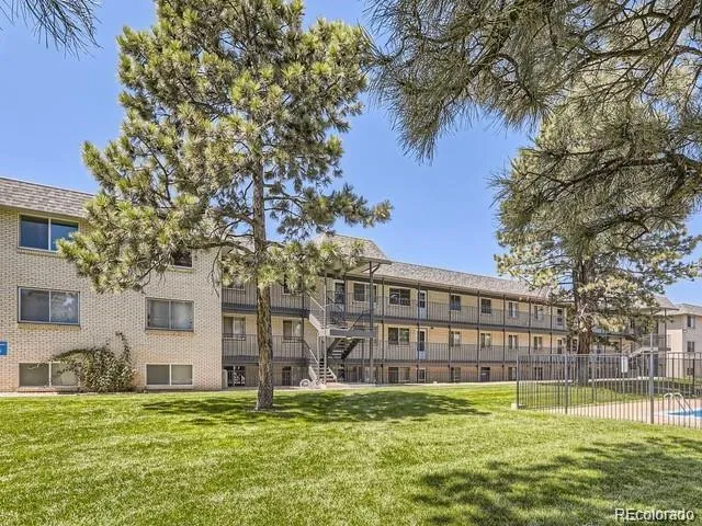 a view of a house with a big yard and large trees