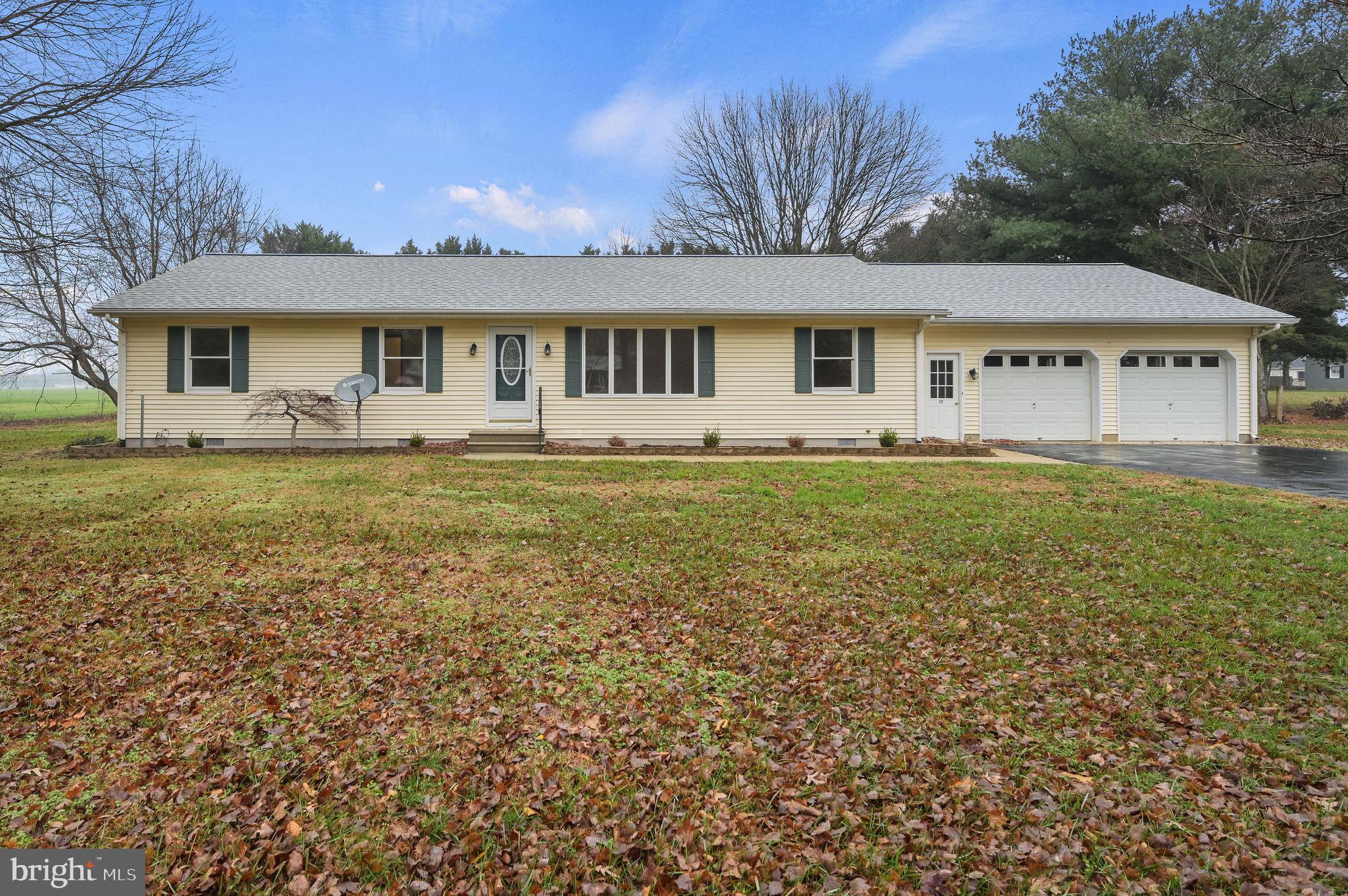 a front view of a house with a garden and yard