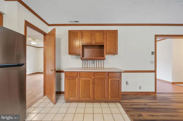 a view of a hallway with wooden floor and a cabinet