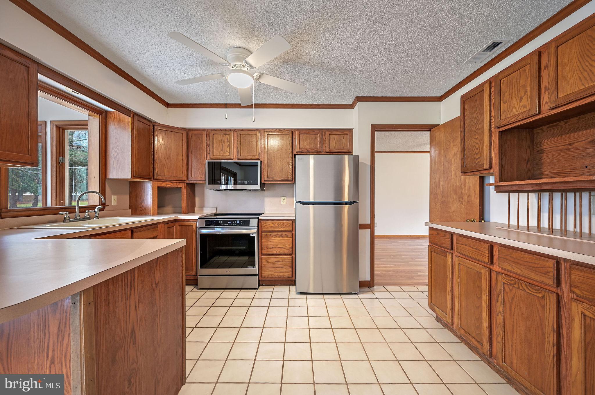311 Sophers Row Magnolia, DE 19962 - Photo 17 of 40 a kitchen with stainless steel appliances granite countertop a refrigerator a stove and a sink with wooden floors