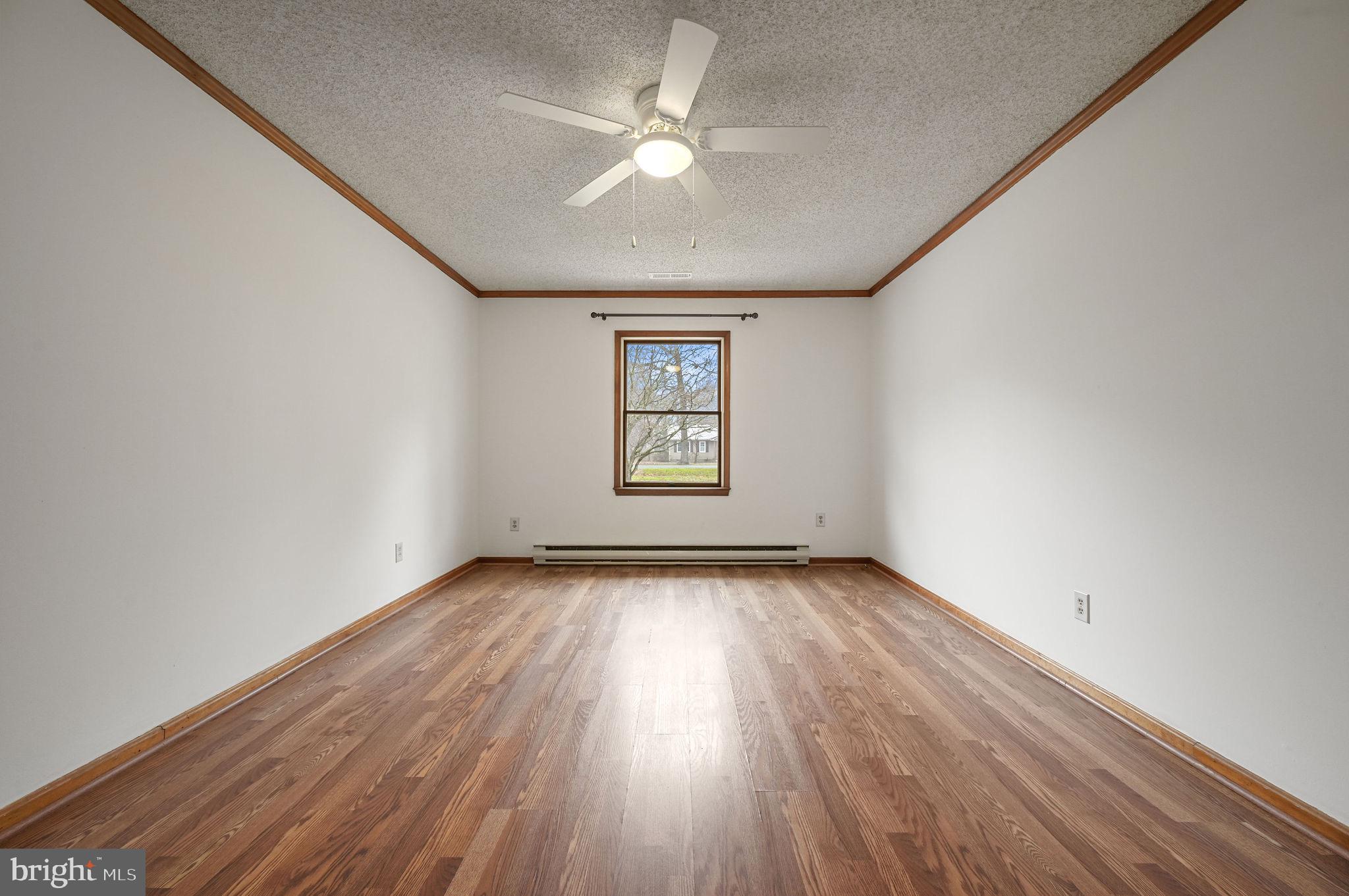 311 Sophers Row Magnolia, DE 19962 - Photo 23 of 40 an empty room with wooden floor chandelier fan and windows