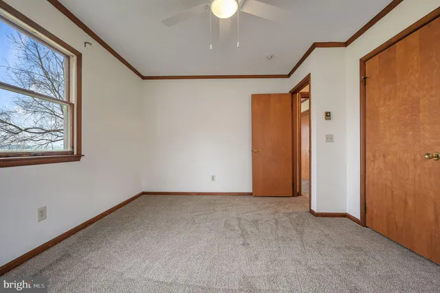 a view of an empty room with a chandelier fan