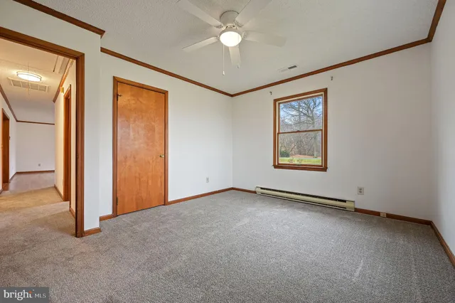 an empty room with closet and a chandelier fan