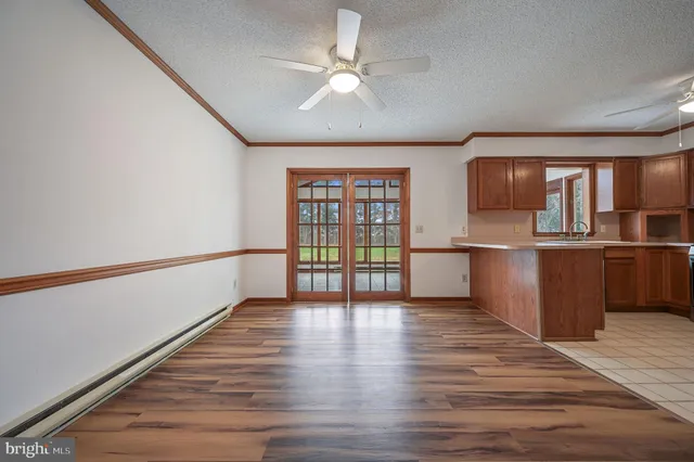 a view of kitchen with stainless steel appliances wooden floor and a large window