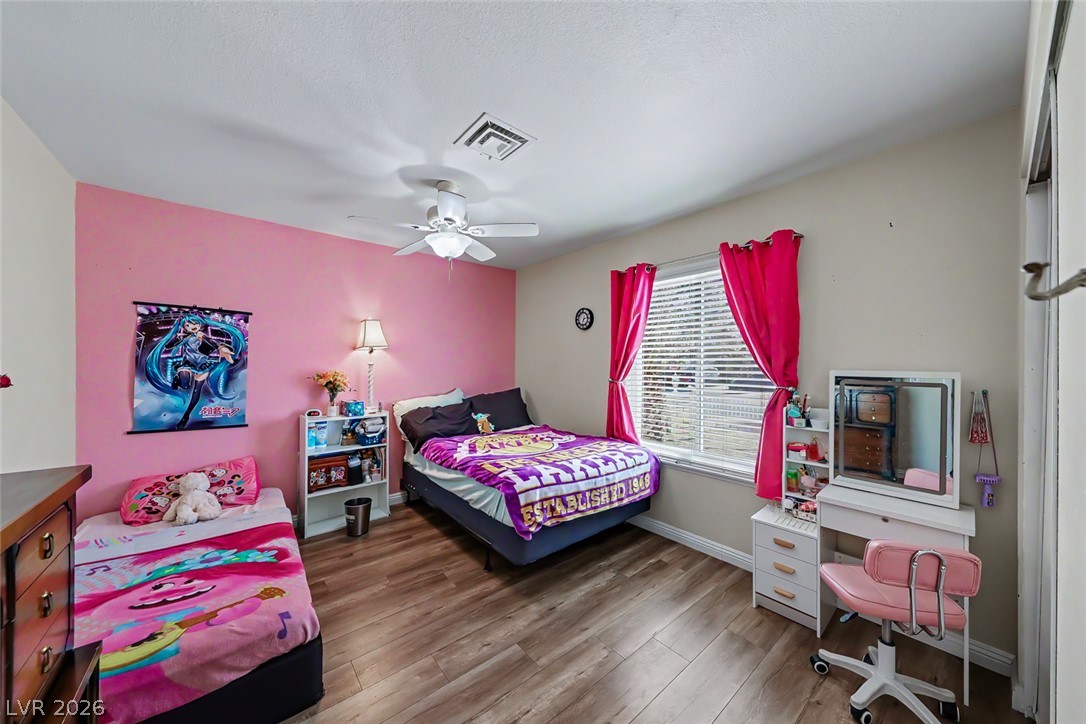 3107 Trueno Road Henderson, NV 89014 - Photo 26 of 37 This cozy bedroom features durable wood flooring and a refreshing ceiling fan for year-round comfort.