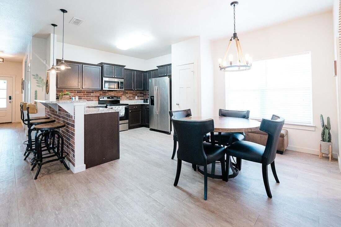 2118 9th Street Lubbock, TX 79401 - Photo 11 of 28 a view of a dining room and livingroom with furniture wooden floor a chandelier